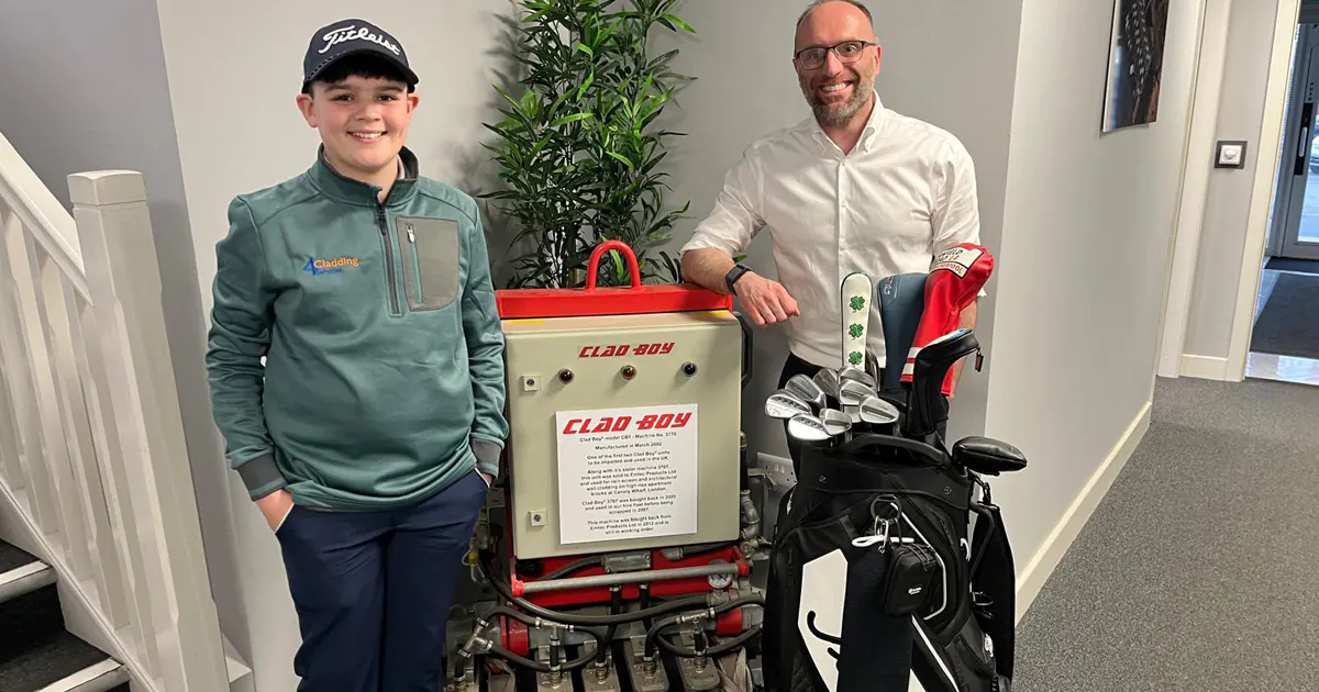 Two people standing indoors, one boy in golf attire with 4 Cladding logo and a man in white shirt, beside golf clubs and vacuum lifting equipment